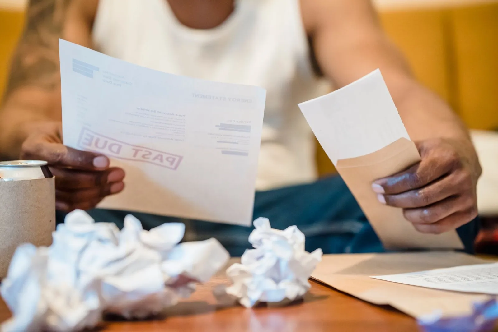 Photo réaliste d'une personne lisant une lettre d'huissier devant des factures, ambiance tendue.